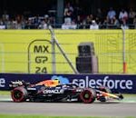 Dynamic shot of an F1 car racing at Mexico City Grand Prix with a cheering crowd in the background.